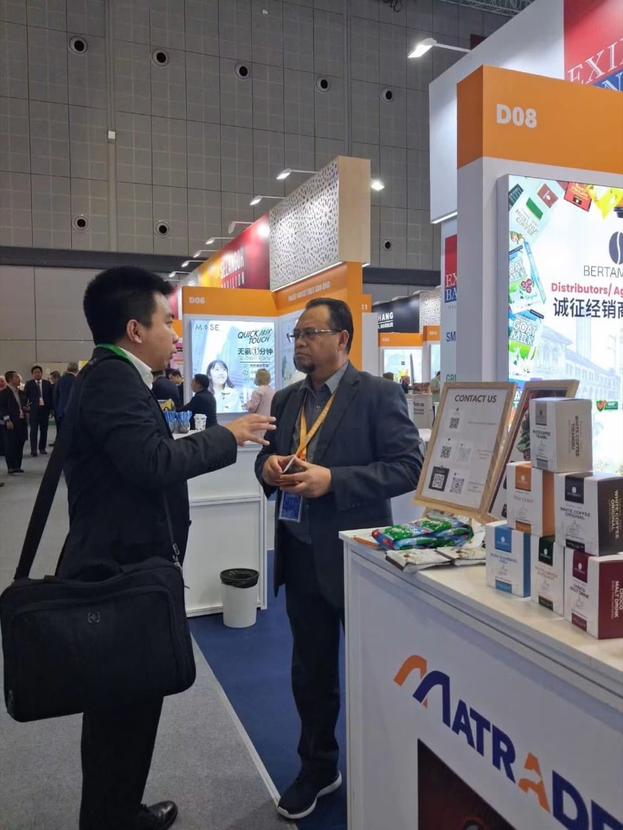 BERTAMBEST representative discussing distribution with a visitor at the MATRADE China pavilion